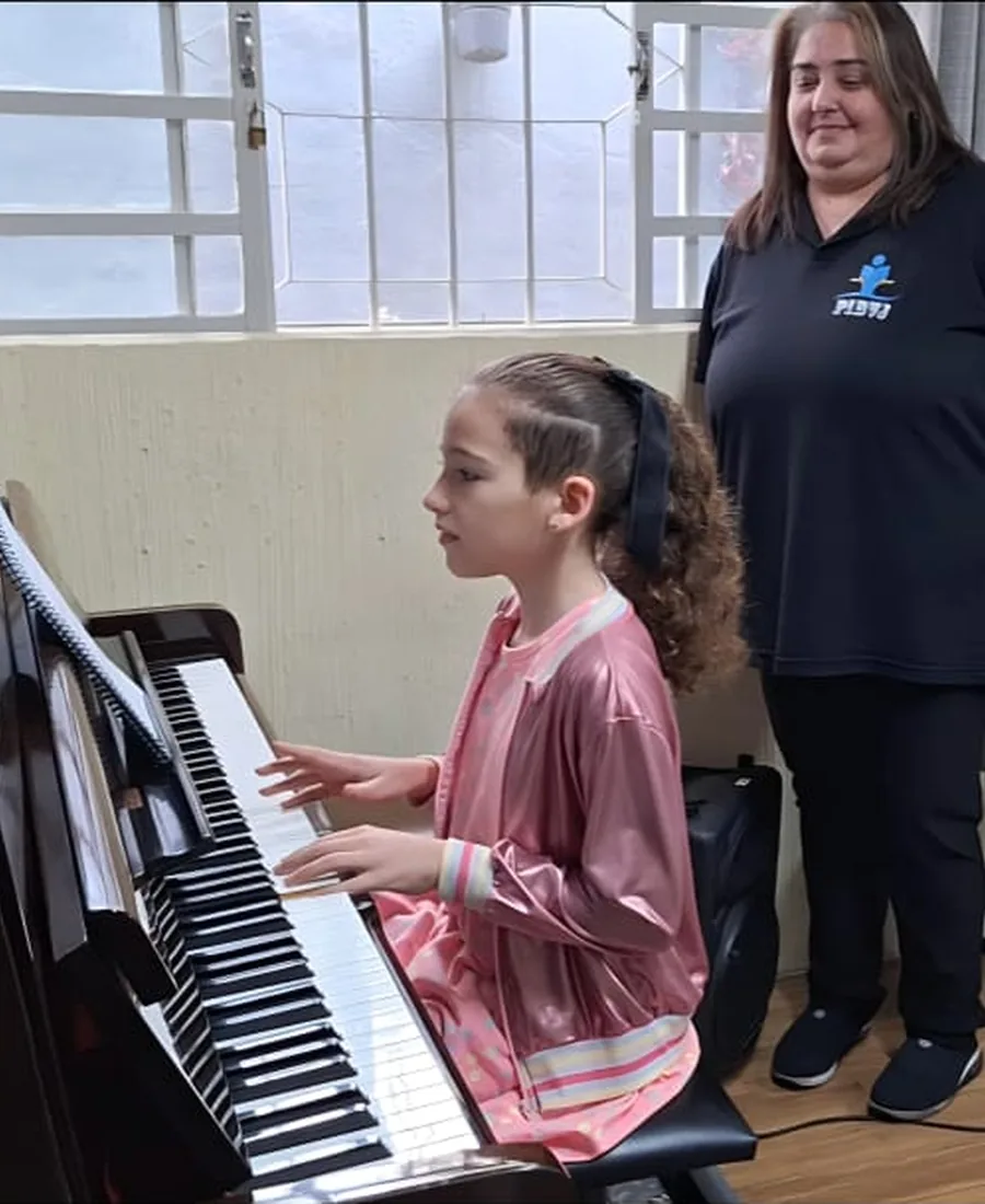 Aluna em aula de piano com a professora